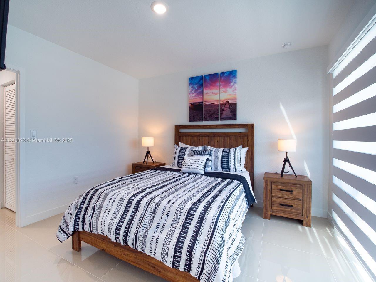 25718 Southwest 143rd Path Homestead, FL 33032 - Photo 11 of 26 a bedroom with a bed and a window