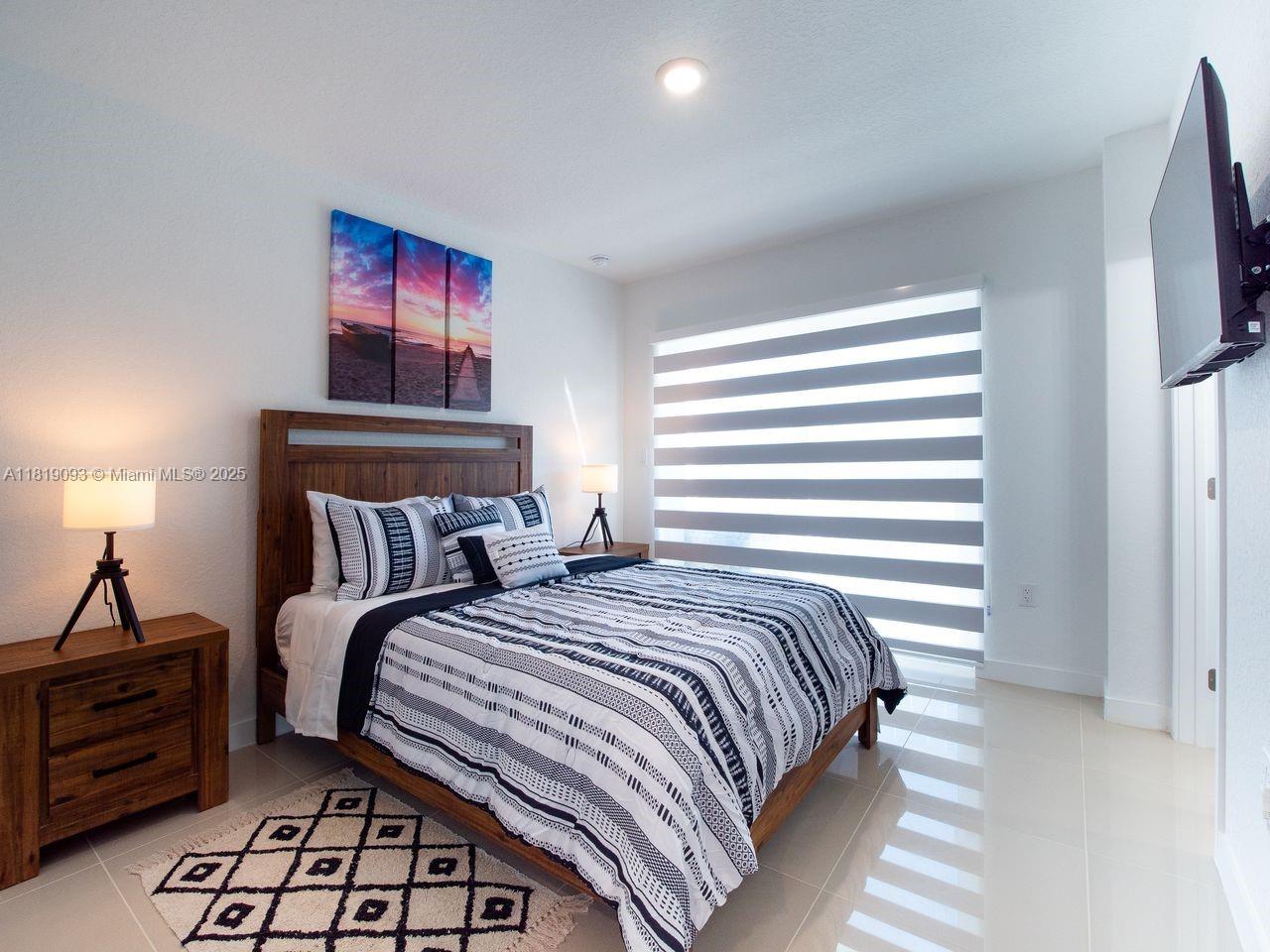 25718 Southwest 143rd Path Homestead, FL 33032 - Photo 12 of 26 a bedroom with a bed and a chandelier