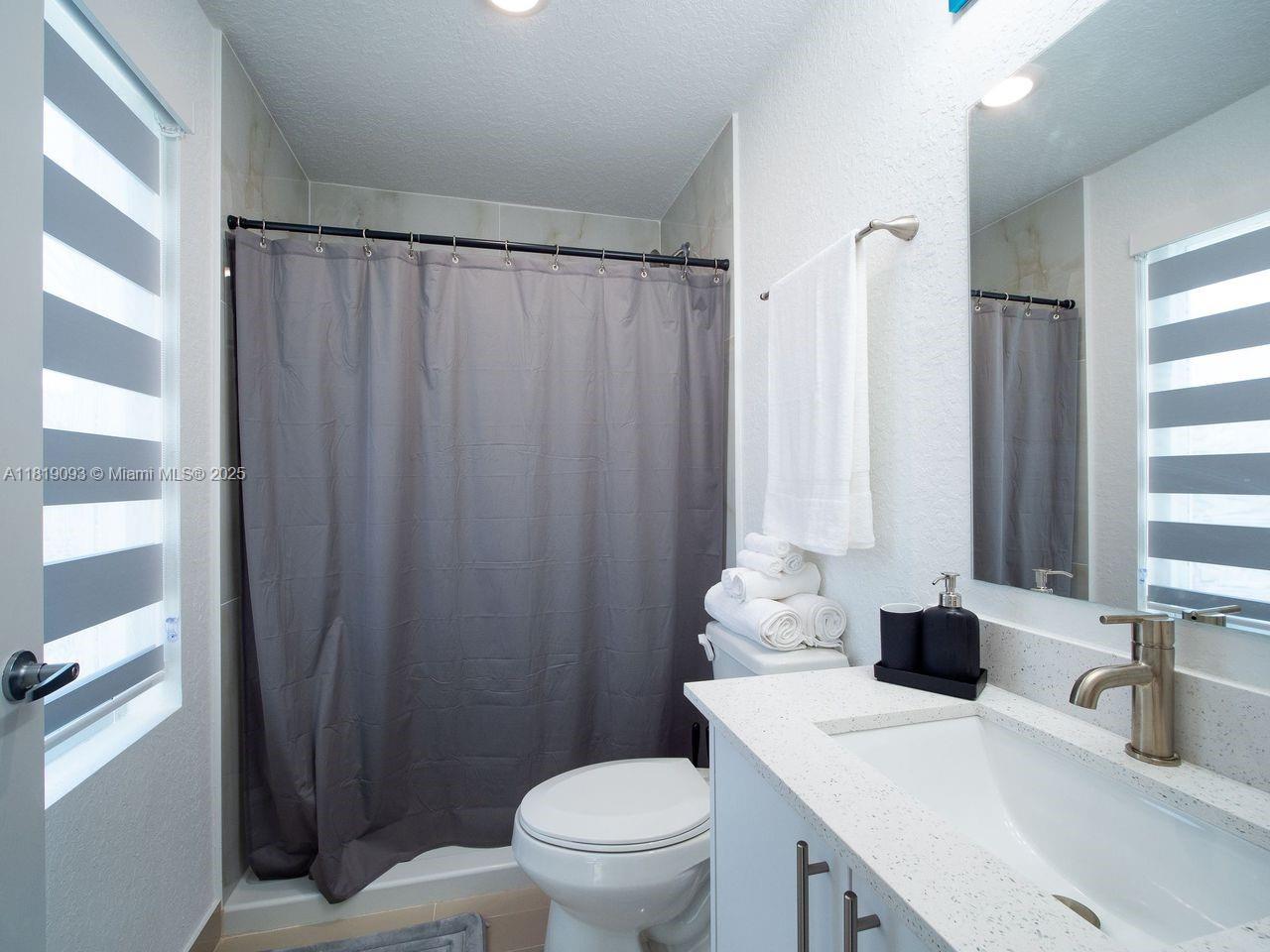 25718 Southwest 143rd Path Homestead, FL 33032 - Photo 13 of 26 a bathroom with a sink toilet vanity and shower