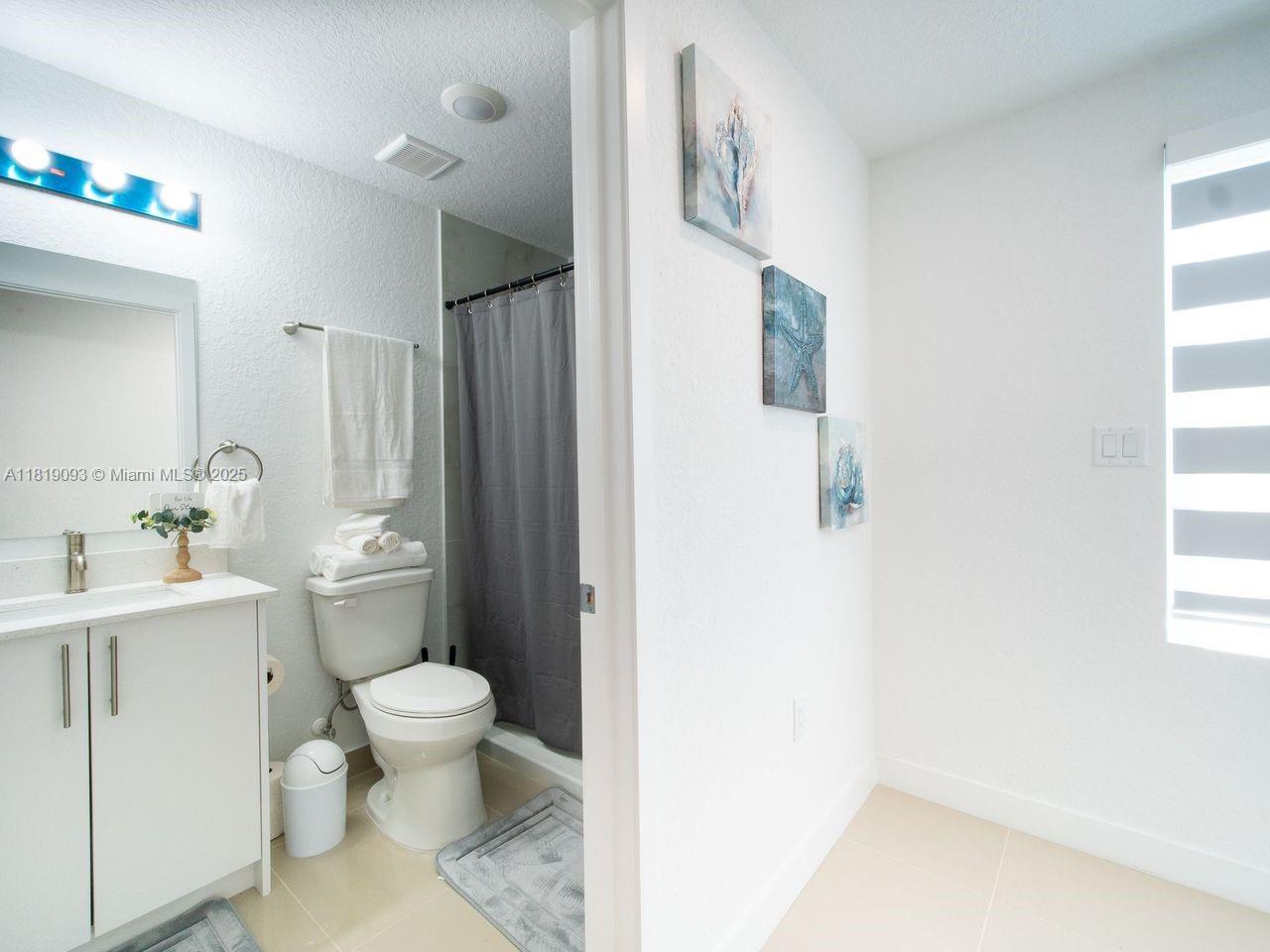25718 Southwest 143rd Path Homestead, FL 33032 - Photo 16 of 26 a bathroom with a toilet a sink and a window