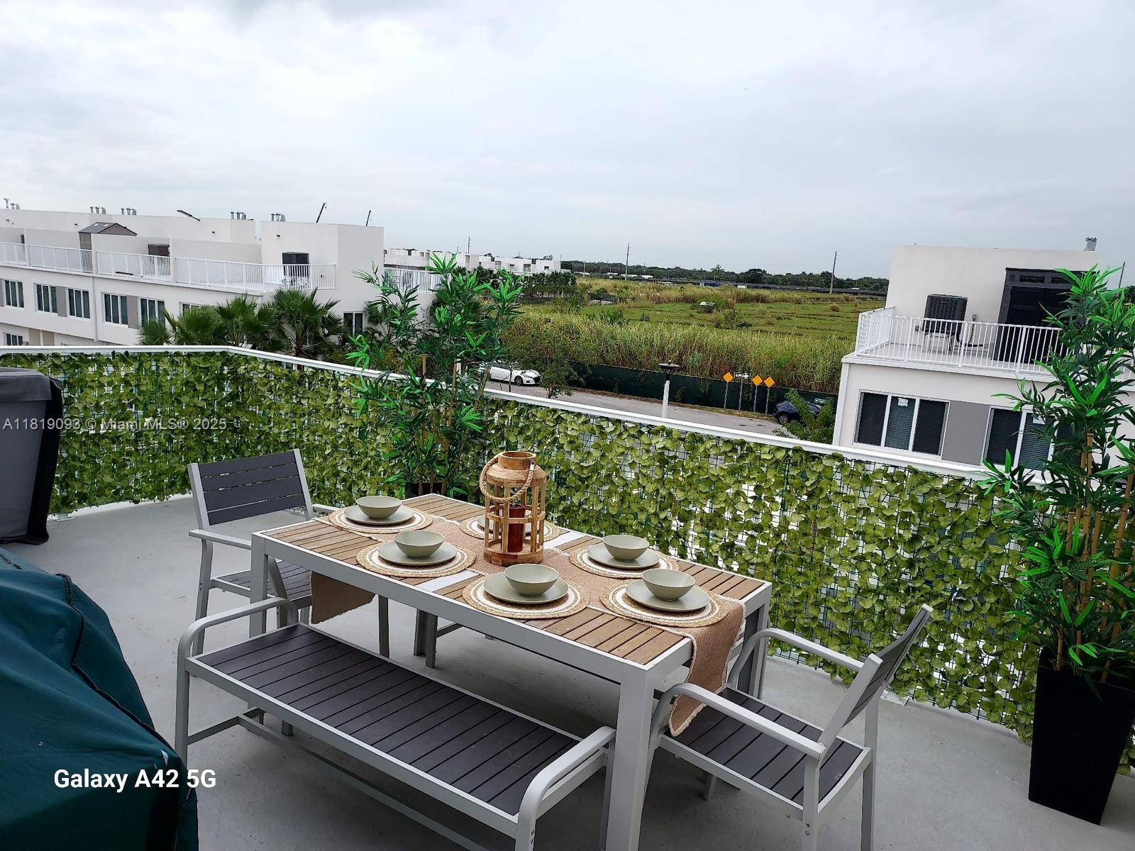 25718 Southwest 143rd Path Homestead, FL 33032 - Photo 21 of 26 a view of a patio with table and chairs and potted plants