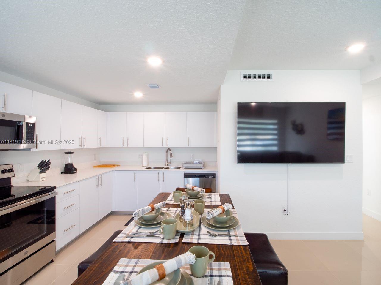 25718 Southwest 143rd Path Homestead, FL 33032 - Photo 5 of 26 a kitchen with stainless steel appliances a stove a sink and a microwave