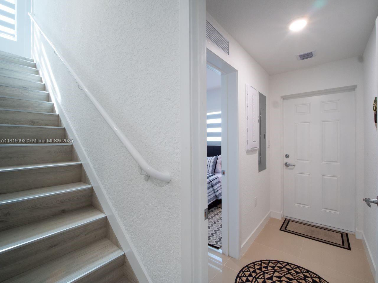 25718 Southwest 143rd Path Homestead, FL 33032 - Photo 10 of 26 a view of entryway with stairs and a floor to ceiling window