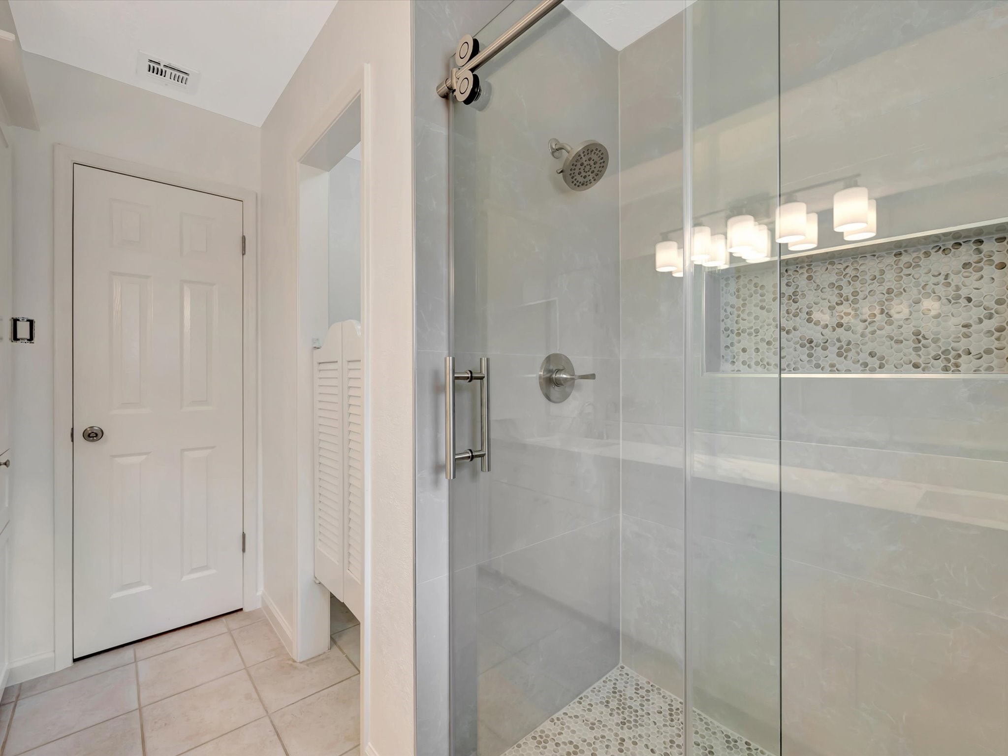 10340 Rocky Hollow Road La Porte, TX 77571 - Photo 26 of 38 Primary walk-in shower featuring large-format porcelain tile and a sliding barn-style glass door.
