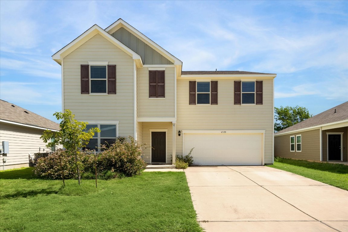 a front view of a house with a yard and garage