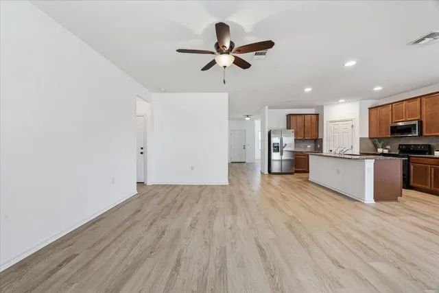 a view of kitchen with cabinets stainless steel appliances and wooden floor