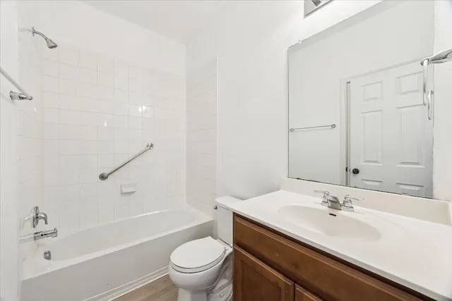 a bathroom with a granite countertop sink a toilet and a bathtub