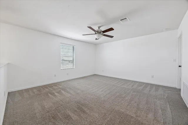 an empty room with fan and windows
