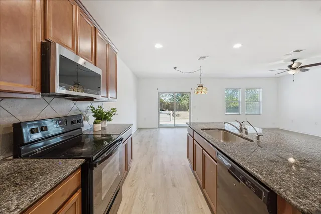 a kitchen with granite countertop stainless steel appliances window a sink and counter space