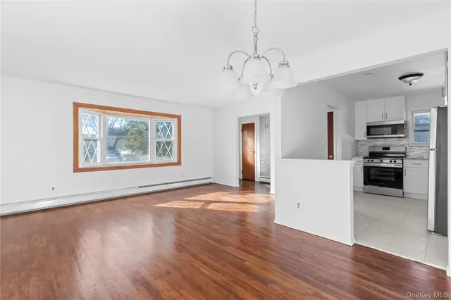a view of a kitchen with microwave and wooden floor