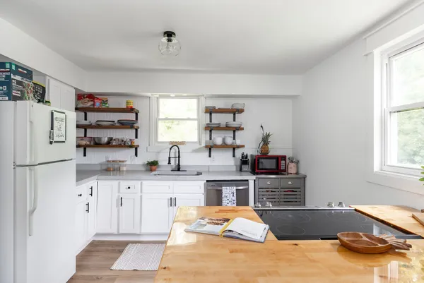 a kitchen with stainless steel appliances kitchen island granite countertop a refrigerator and a sink
