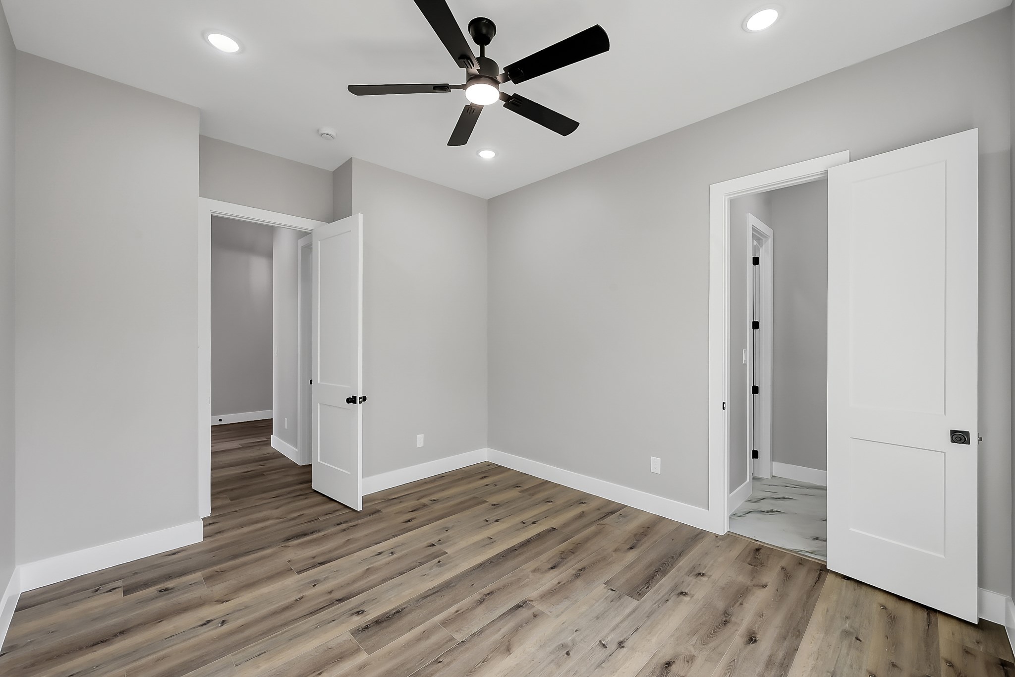 135 Wick Willow Road Montgomery, TX 77356 - Photo 38 of 48 an empty room with wooden floor and a ceiling fan