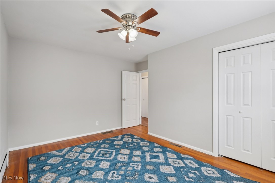 611 Wilson Street Struthers, OH 44471 - Photo 28 of 44 Unfurnished bedroom featuring light wood-style floors, ceiling fan, a closet, and a baseboard heating unit