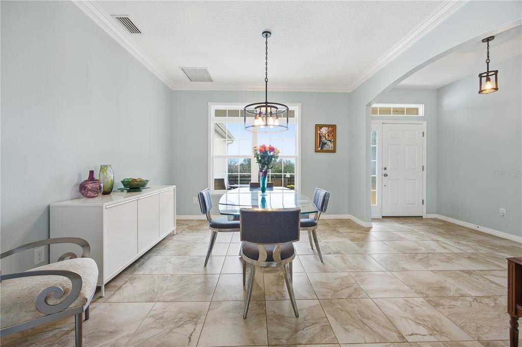 5608 Strong Point Weirsdale, FL 32195 - Photo 24 of 56 a dining room with furniture window and chandelier