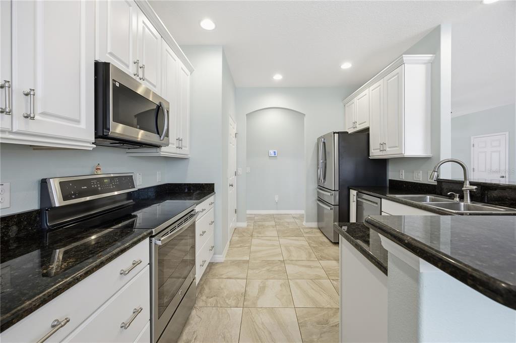 5608 Strong Point Weirsdale, FL 32195 - Photo 31 of 56 a kitchen with stainless steel appliances granite countertop a sink and a stove