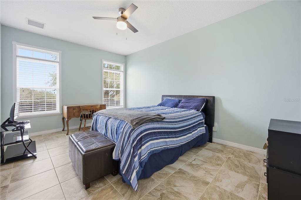 5608 Strong Point Weirsdale, FL 32195 - Photo 40 of 56 a bedroom with a bed and wooden floor