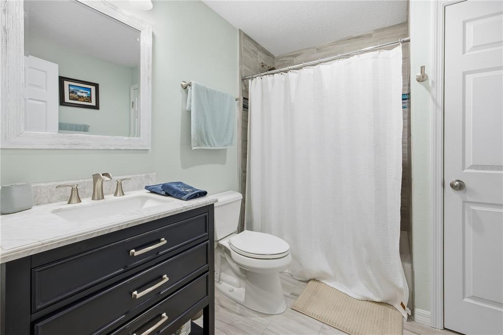 5608 Strong Point Weirsdale, FL 32195 - Photo 53 of 56 a bathroom with a granite countertop sink toilet and shower