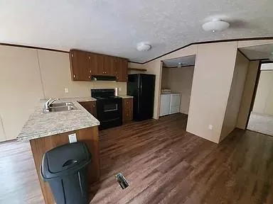 a kitchen with a sink a refrigerator freezer a stove and a dishwasher with wooden floor