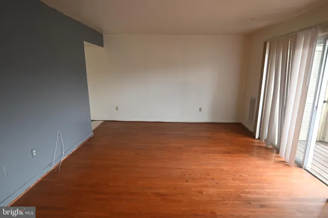 an empty room with wooden floor and a window