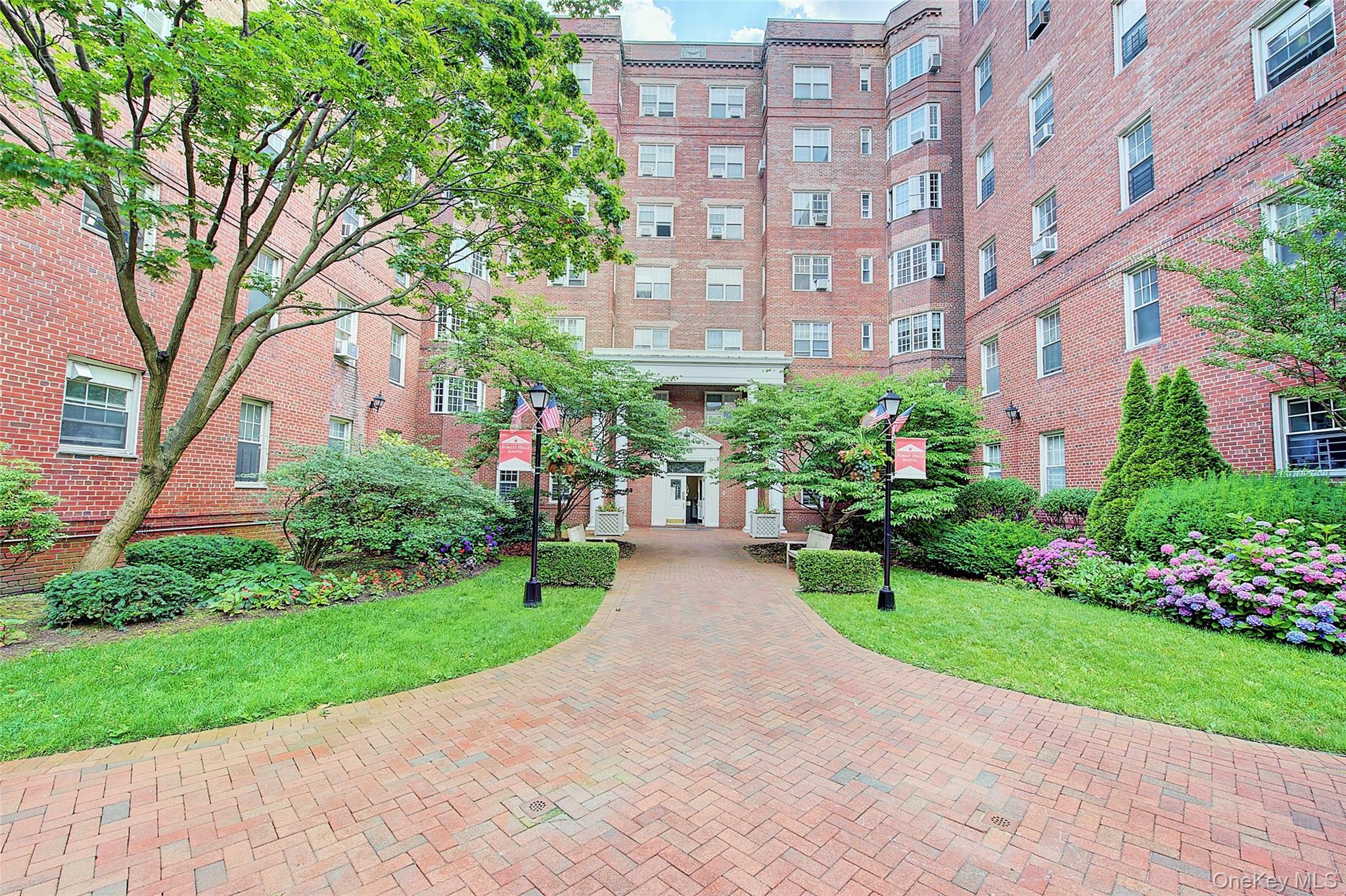76-36 113th Street, Unit 4J Queens, NY 11375 - Photo 1 of 1 a view of a brick building next to a yard
