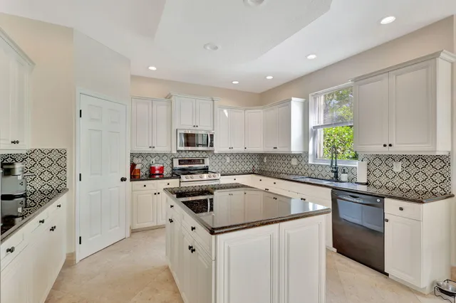 a kitchen with granite countertop a sink stainless steel appliances and cabinets