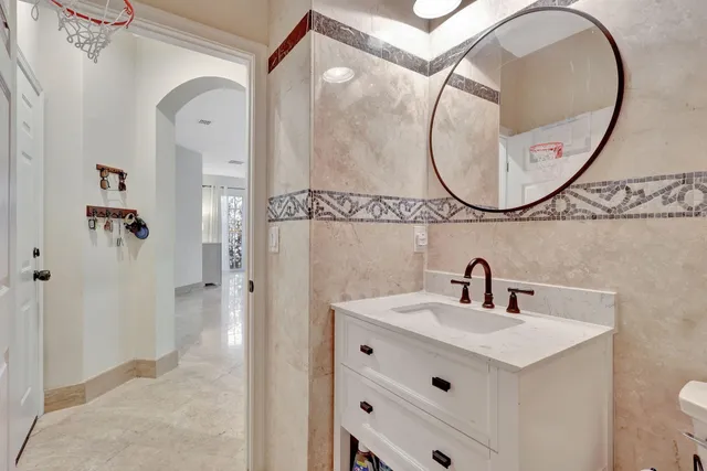 a bathroom with a sink a mirror a vanity and a shower