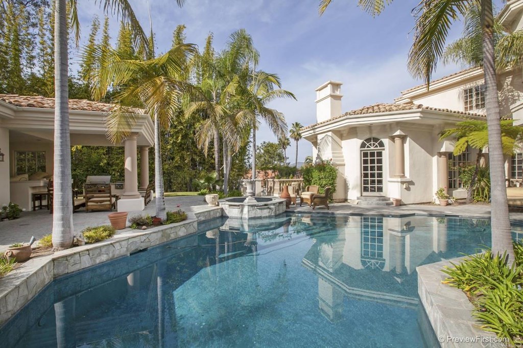 a view of a swimming pool with outdoor seating and a pathway