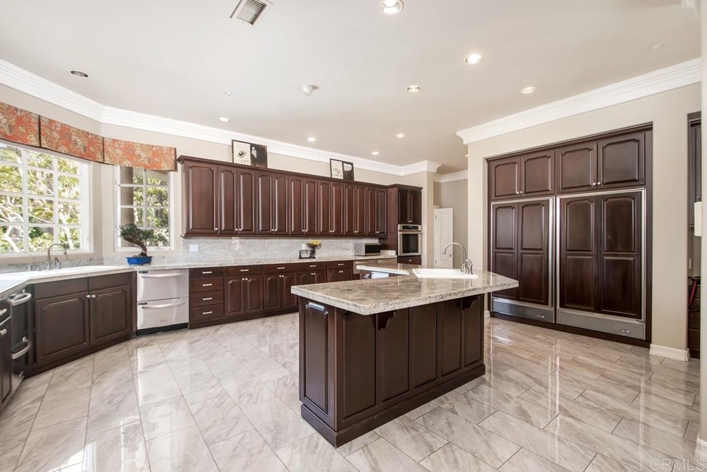 17101 Circa Oriente Rancho Santa Fe, CA 92067 - Photo 17 of 23 a kitchen with a stove sink and cabinets
