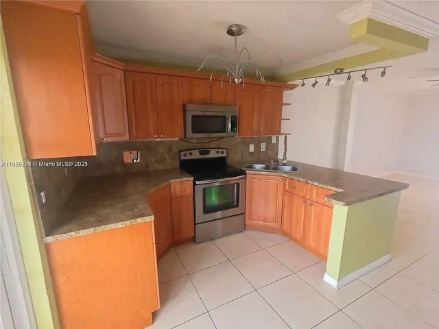 a kitchen with granite countertop a refrigerator and a stove top oven