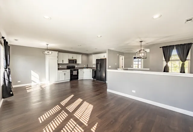 a view of a living room with kitchen furniture and a wooden floor