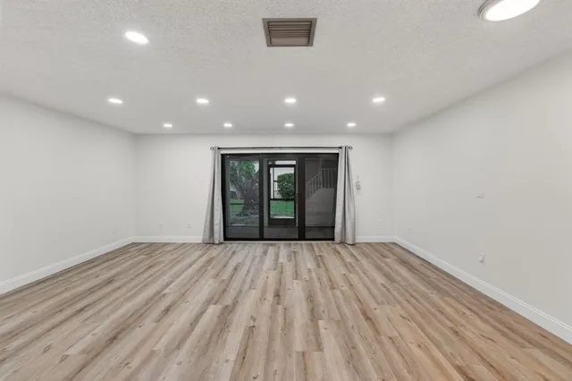 a view of a hallway with wooden floor and entryway