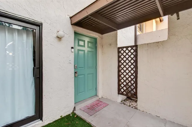 a view of an empty room with wooden floor and windows