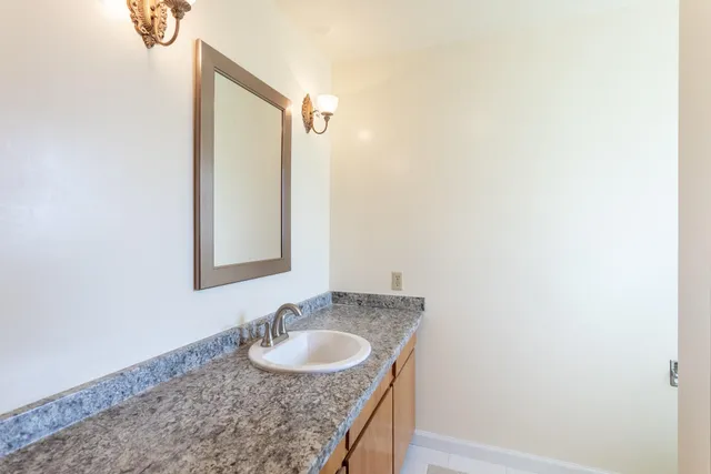 a bathroom with a granite countertop sink and a mirror