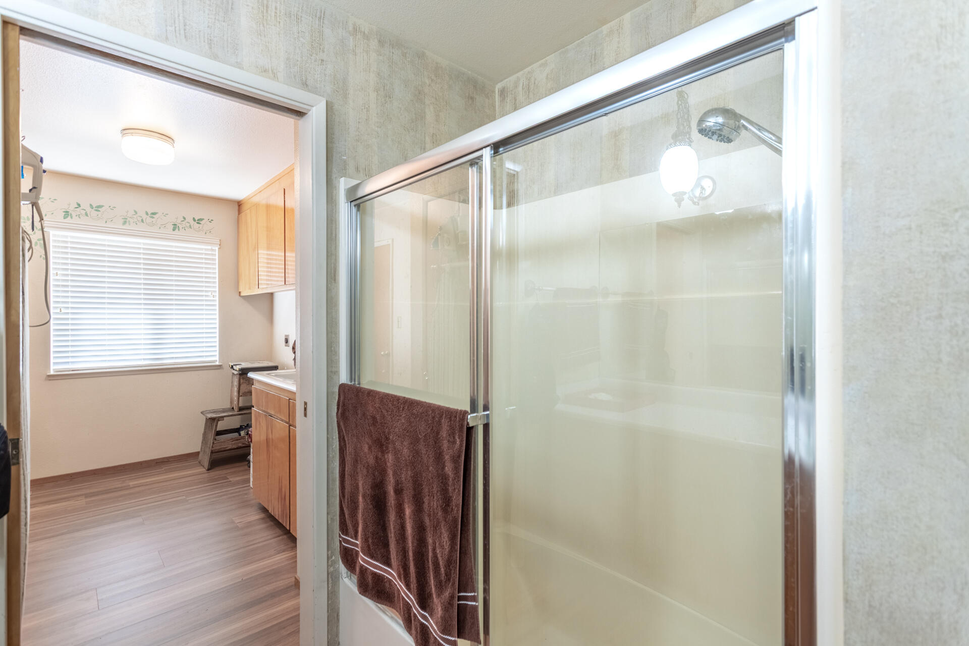 8818 Valley View Road Redding, CA 96001 - Photo 15 of 37 a bathroom with a glass shower door and a window