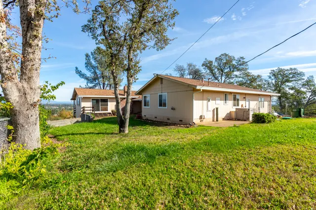a view of a house with backyard and a tree