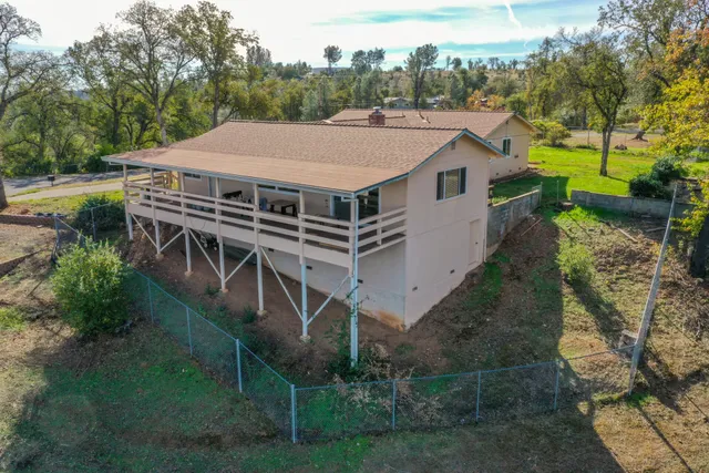 a aerial view of a house with a yard table and chairs