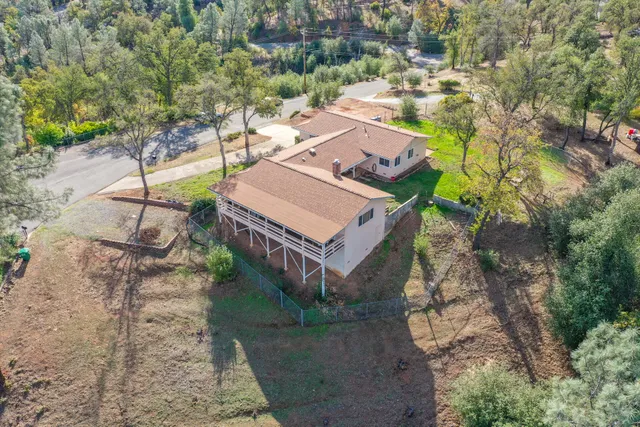 an aerial view of a house with a yard and large tree