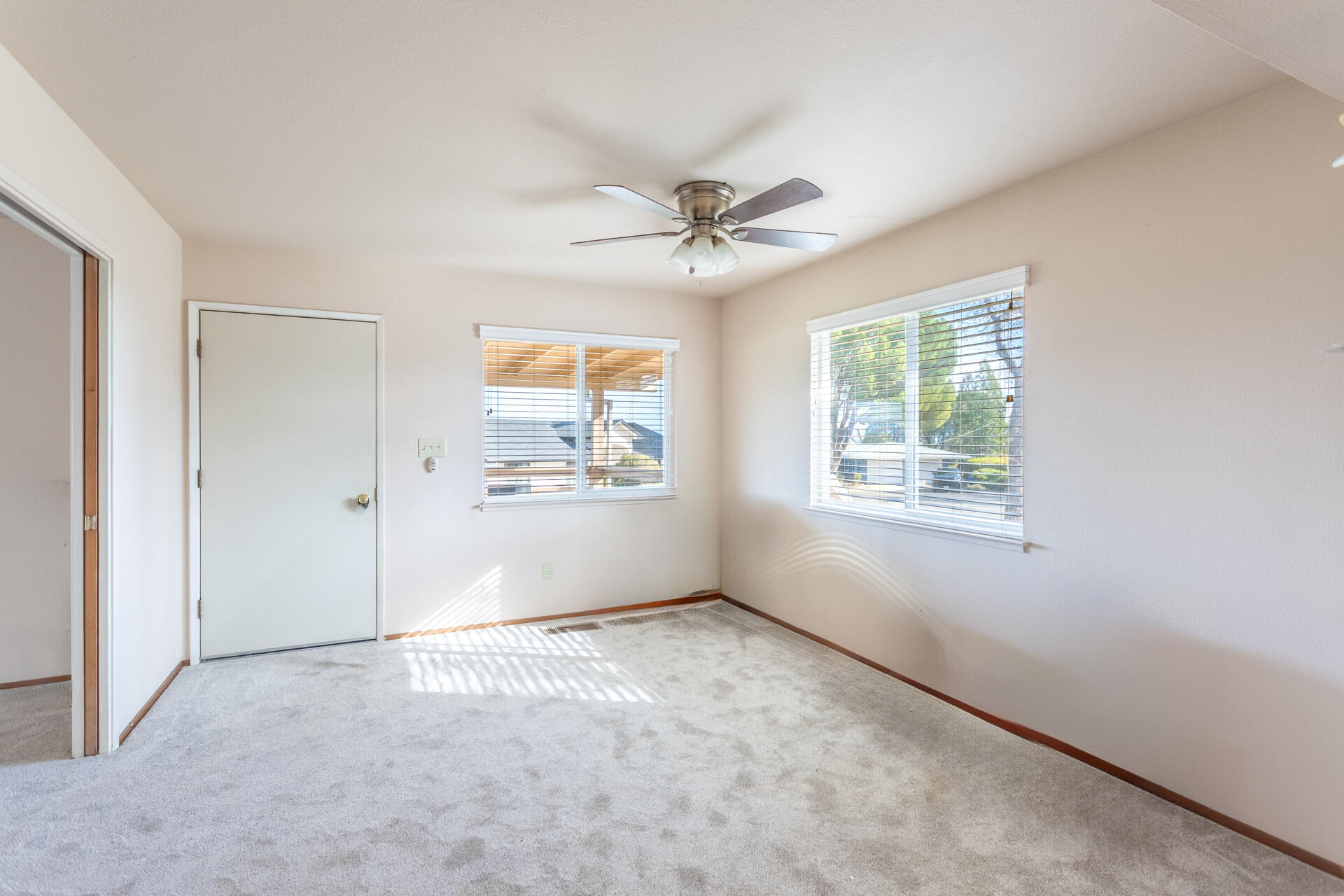 8818 Valley View Road Redding, CA 96001 - Photo 9 of 37 an empty room with windows and fan