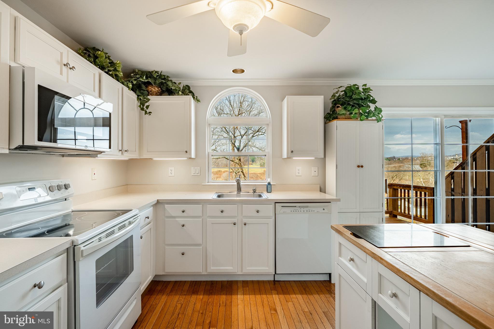 1406 Harbour Ridge Lane Downingtown, PA 19335 - Photo 15 of 57 a kitchen with a sink dishwasher a stove a microwave oven and a dining table with wooden floor