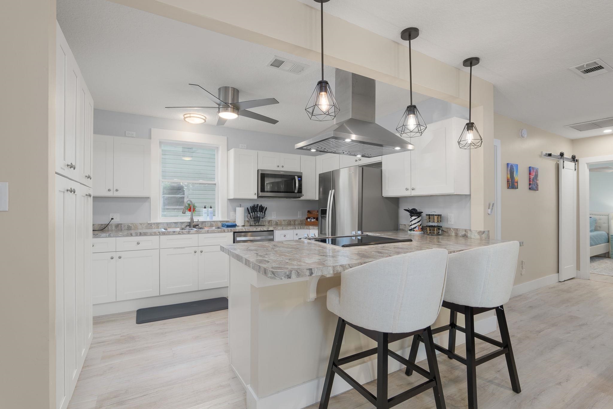 2 Clark Street St. Augustine, FL 32084 - Photo 6 of 39 a kitchen with stainless steel appliances kitchen island a table chairs and a sink