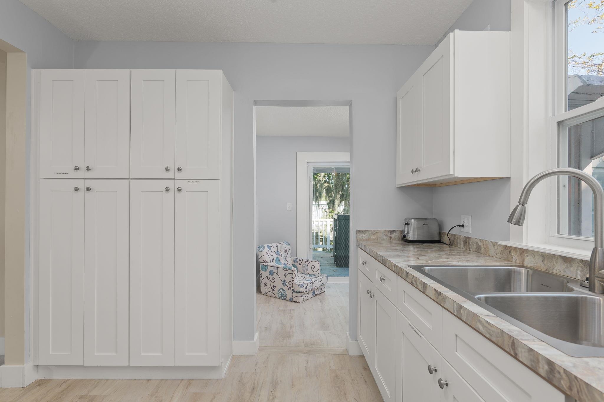 2 Clark Street St. Augustine, FL 32084 - Photo 9 of 39 a kitchen with granite countertop white cabinets and sink
