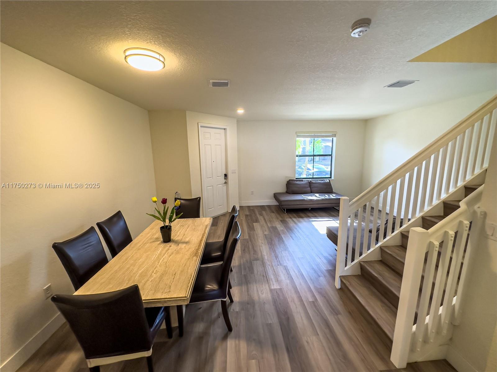 3349 West 105th Terrace, Unit 3349 Hialeah, FL 33018 - Photo 4 of 11 a view of a dining room with furniture and wooden floor