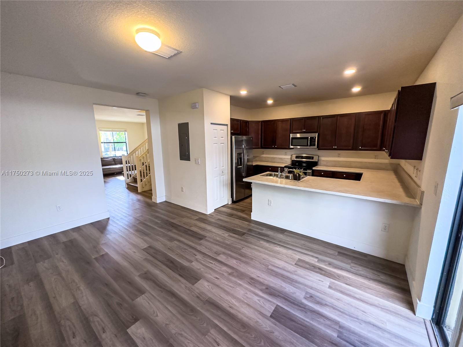 3349 West 105th Terrace, Unit 3349 Hialeah, FL 33018 - Photo 6 of 11 a kitchen with stainless steel appliances a refrigerator sink and microwave