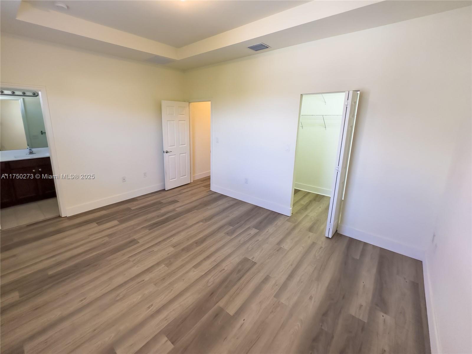 3349 West 105th Terrace, Unit 3349 Hialeah, FL 33018 - Photo 10 of 11 a view of an empty room with wooden floor and a window