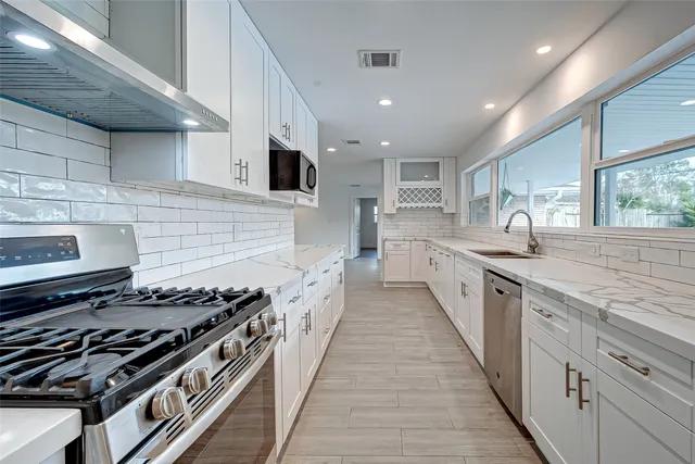 a kitchen with sink stove and cabinets