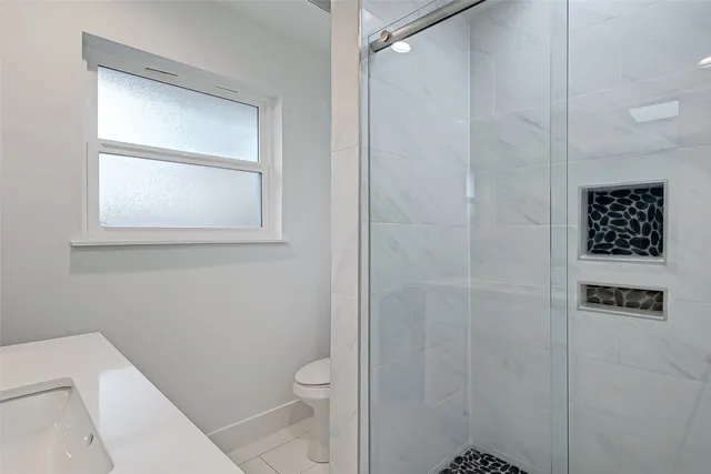 a bathroom with a toilet and a shower