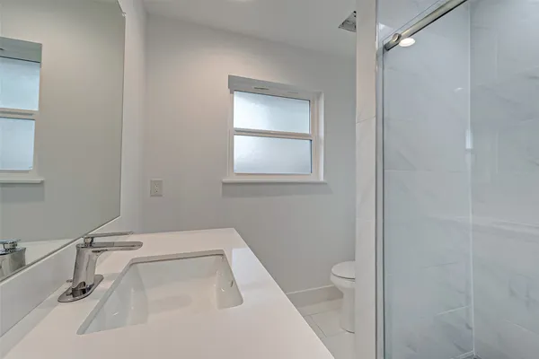 a bathroom with a sink a toilet and a mirror