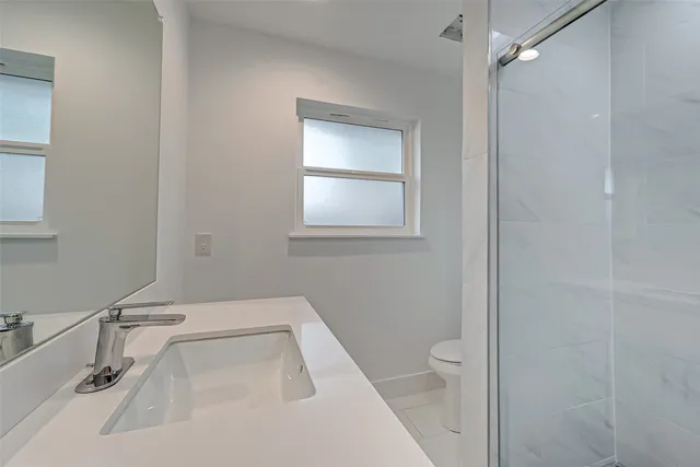 a bathroom with a sink a toilet and a mirror