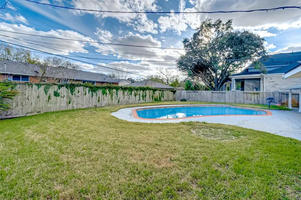 a view of swimming pool with outdoor seating and yard in back