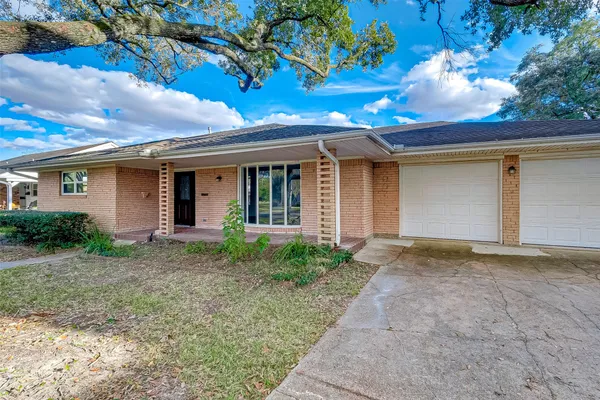 a view of a house with a tree in front of it